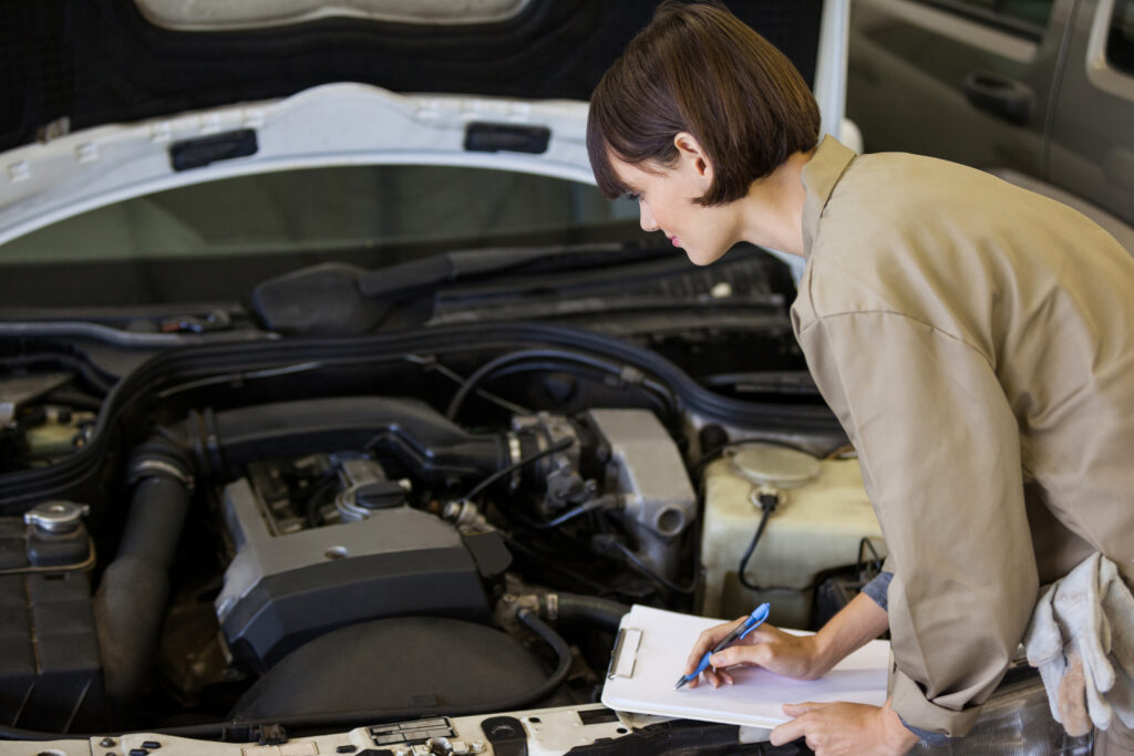 Female mechanic preparing a check list at repair garage